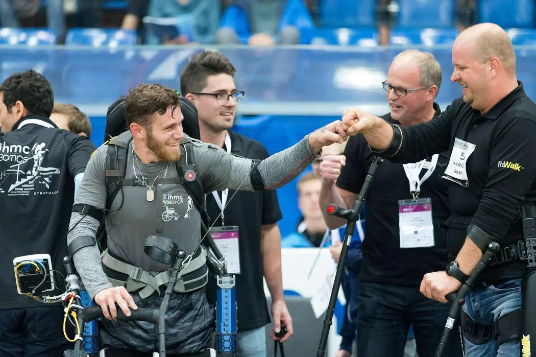 IHMC Pilot Mark Daniel and Cybathlon champion Van Reuschen. Tyson Cobb looks on. Credit: ETH Zürich/Alessandro Della Bella