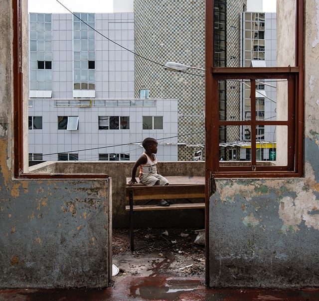 A child looks out at city streets from the balcony of a damaged school turned shelter for over 3,000 people in the afternoon of cyclone idai. #mozambique #beira #nikon #cycloneidai #climatechange #urban #urbanlandscape #africa