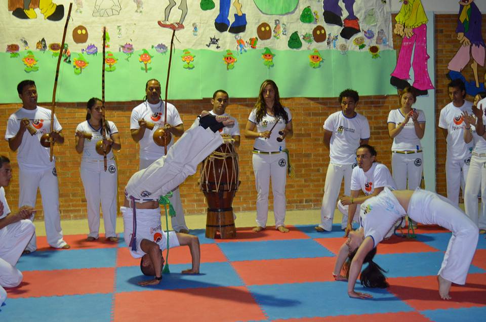 Our project leader and Capoeira trainer Cristhian Casallas plays with one of the students before giving her the new belt