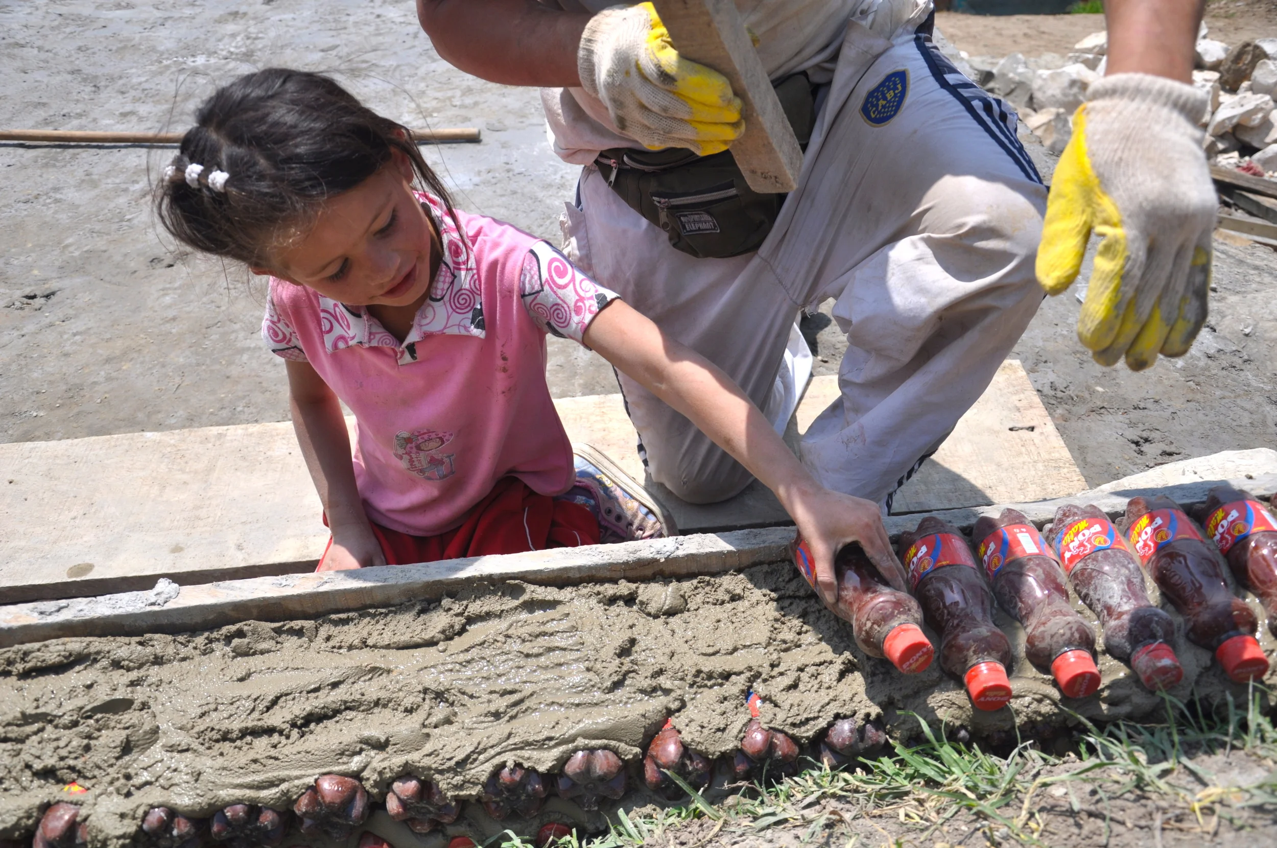 The center was built with the help of the community. Here little Karina helping out in making the walls of plastic bottles filled with sand.