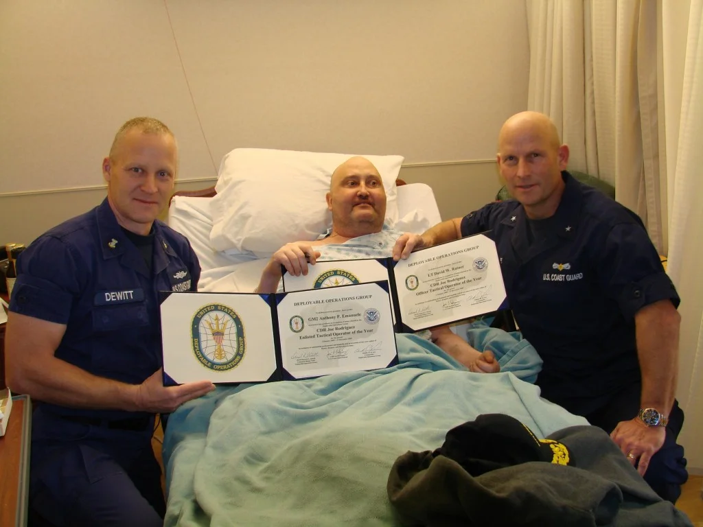 Jan. 14, 2009. From left to right, Command Master Chief Darrick Dewitt, Lt. Cmdr Joe Rodriguez (ret.) and Rear Adm. Dean Lee display signed copies of the Deployable Operations Group’s Tactical Operator of the Year Awards. The awards were recently named after Lt. Cmdr Rodriguez for his contributions to the Deployable Specialized Forces community. (Coast Guard photo by Lt. James McLay)