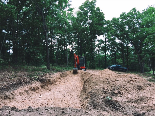  Prepping the site for the studio build. We had to bring in a backhoe to hammer out 3' x 100'&nbsp;of bedrock for the footing. Fun fact, I was swarmed by a nest of yellow-jackets about an hour after this photo was taken. They were by the tree next to