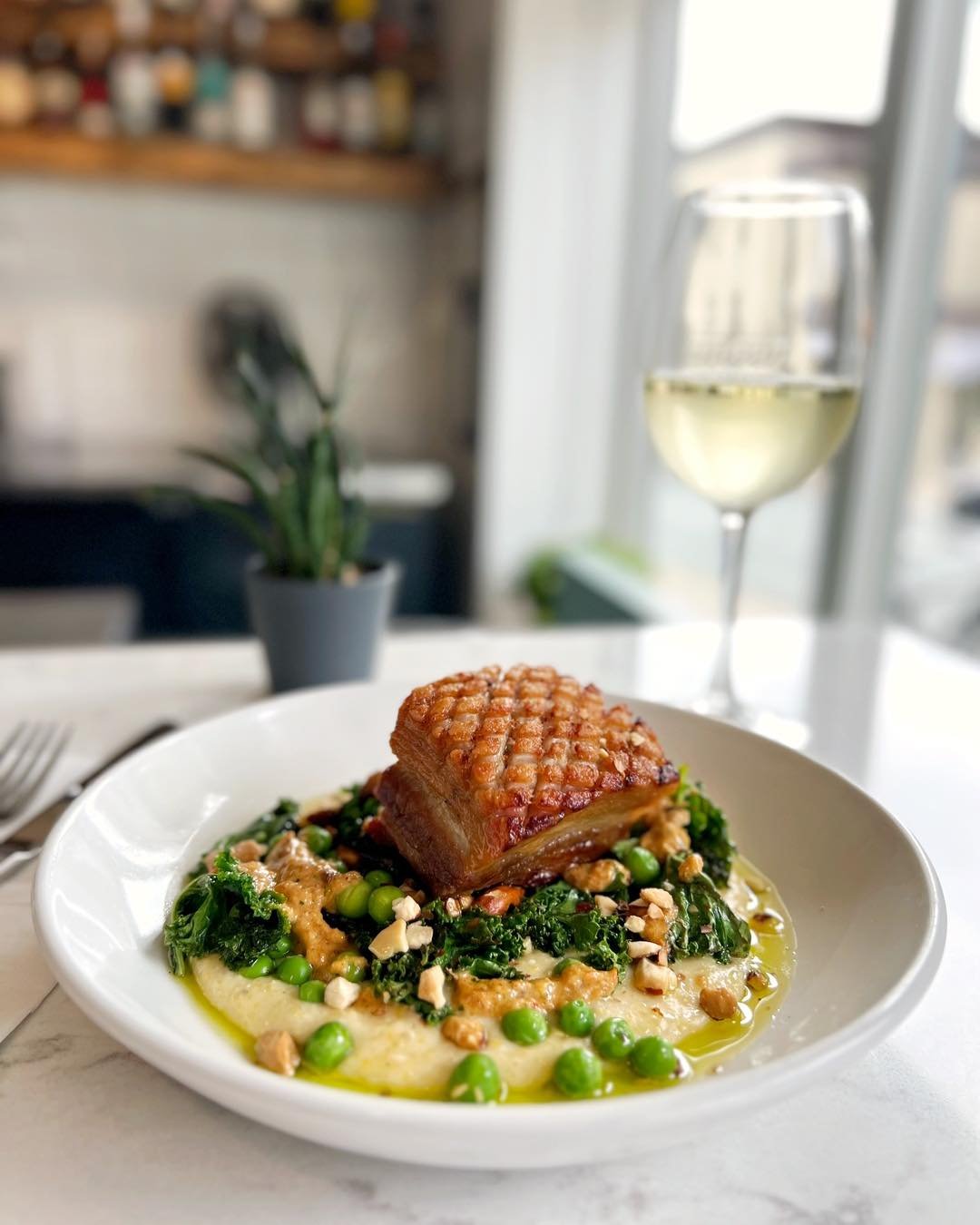 🚨 BEAUTIFUL DISH ALERT 🚨 You don&rsquo;t want to miss out on this weekend&rsquo;s dinner feature &gt;&gt; Crispy Oulton&rsquo;s pork belly, creamy polenta, saut&eacute;ed kale &amp; peas, romesco, toasted almonds. ✅ Checking all the delicious boxes