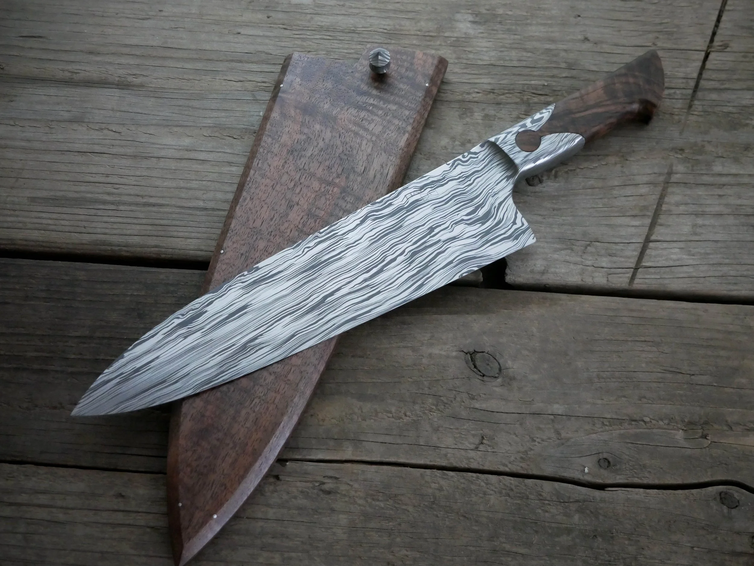 CPM154/NitroV stainless damascus keyhole integral Wester gyuto in midnight ripple pattern.