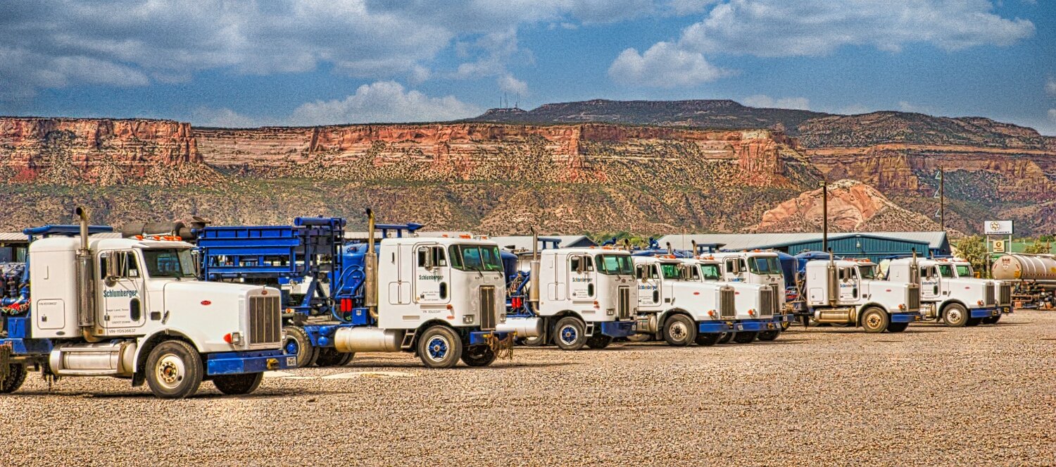 a line of utilities trucks and mountainous desert area