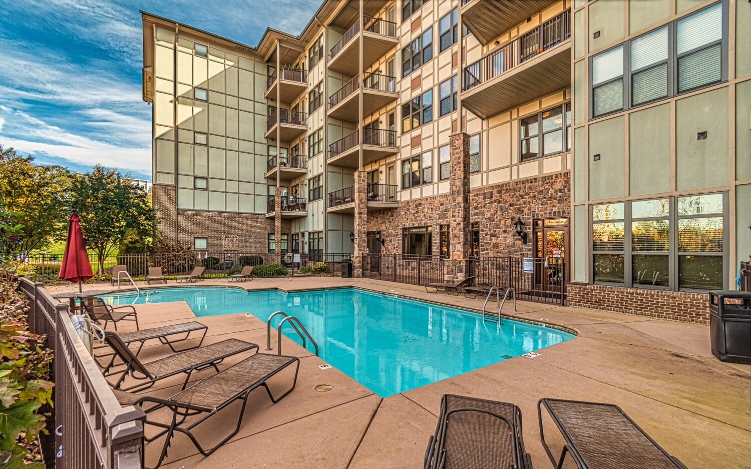 commercial multi floor apartment building and pool and surrounding patio 