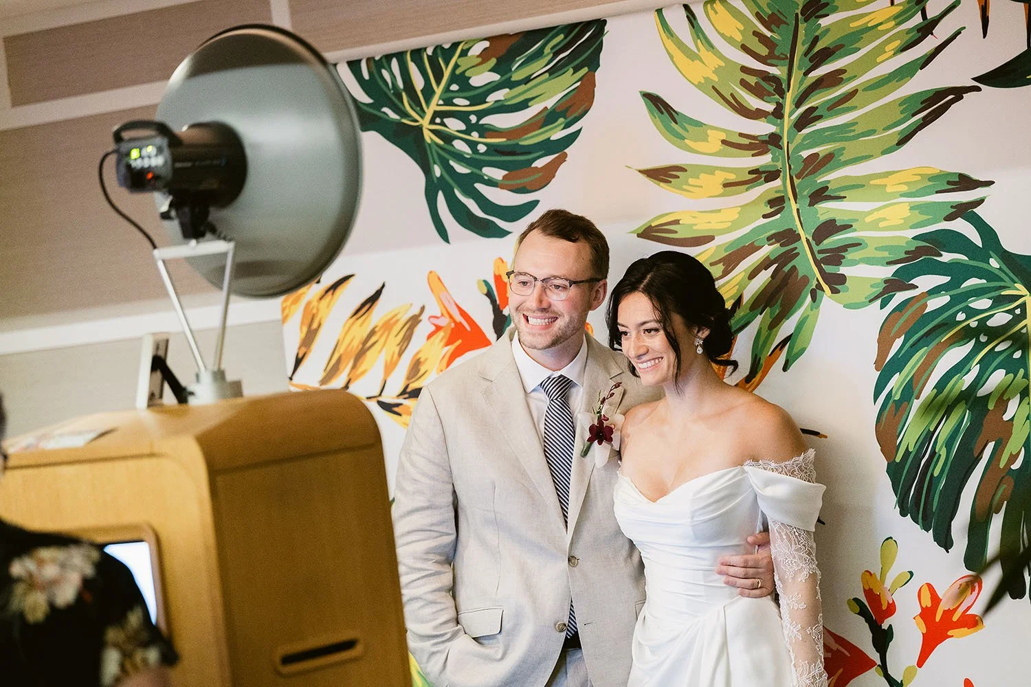 Wedding couple smiling at their photo booth rental at an Oahu wedding
