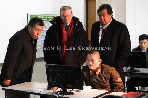 PYONGYANG, North Korea -- Googe Executive Chairman Eric Schmidt (left) and former New Mexico Gov. Bill Richardson (right) watch as a North Korean soldier uses a computer at the Grand People's Study Hall in Pyongyang, North Korea. (Photo credit: Jean H. Lee. All Rights Reserved)