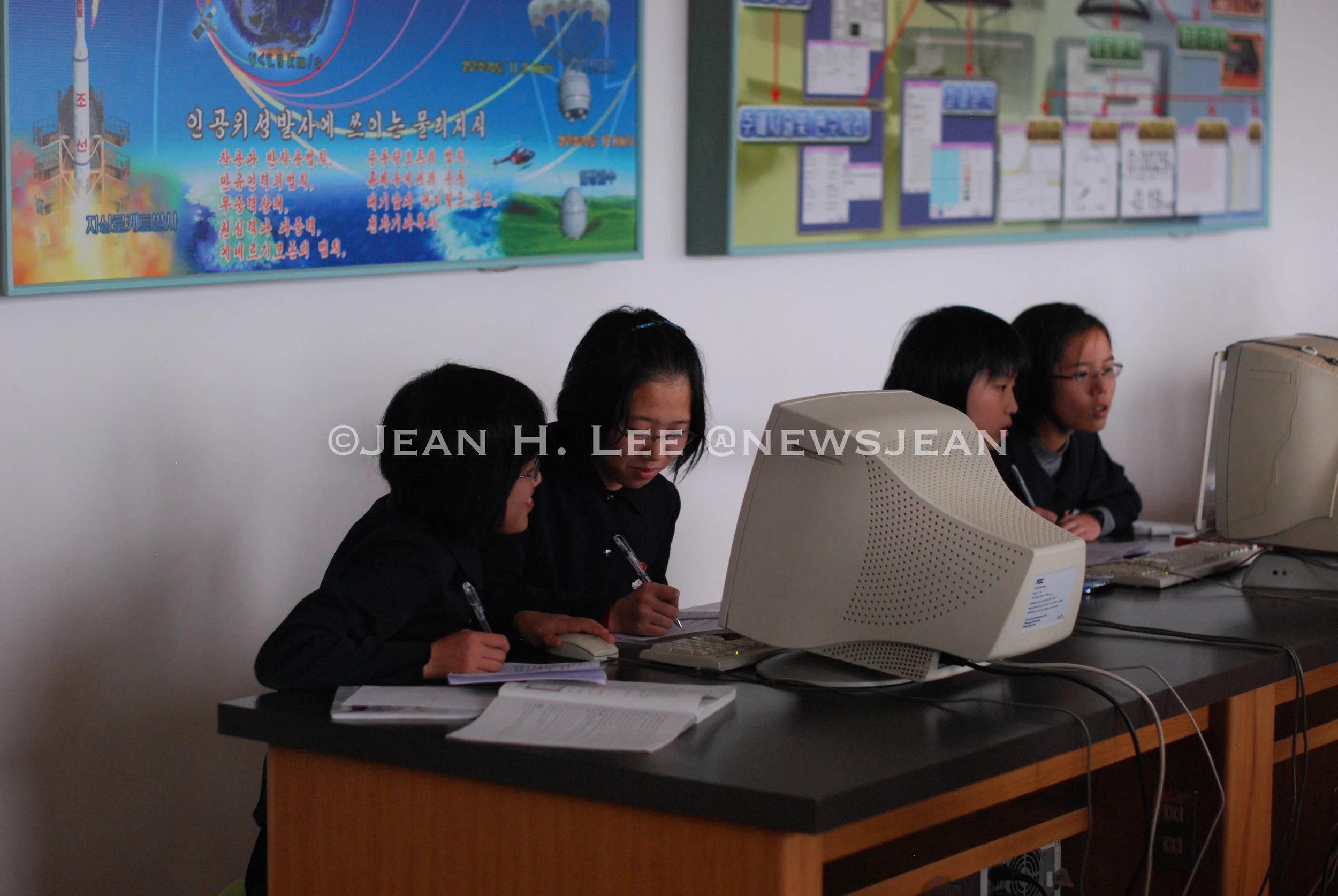  PYONGYANG, North Korea -- Middle school students work on a computer in front of a poster of North Korea's rockets and satellites behind them in this photo taken in Pyongyang, North Korea, on Oct. 24, 2011. (Photo credit: Jean H. Lee) 