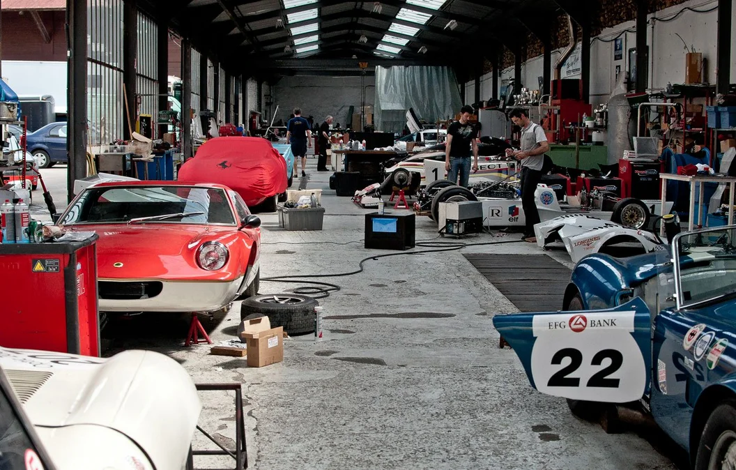 Look behind the folks on the right - The Peugeot in a bay getting much-needed love.