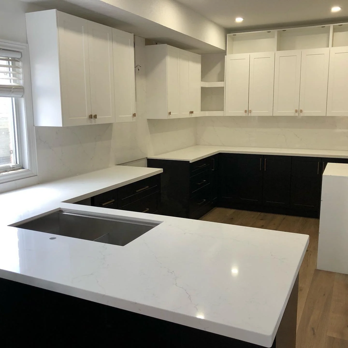 Sekura Quorastone quartz kitchen countertops with bookmatched full height backsplash.