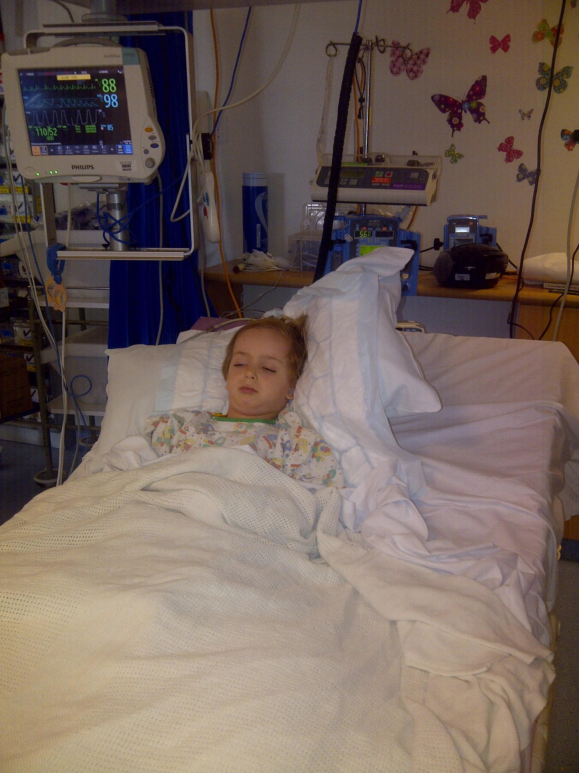 Skye lying in PICU post surgery