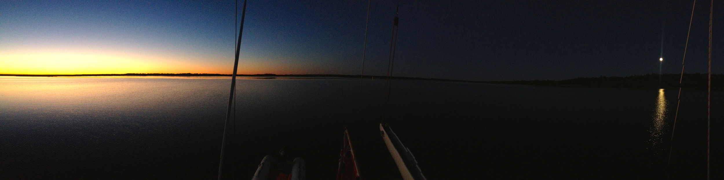 Simultaneous panorama picture of sunset and moonrise (a bit over 180° field of view), from Peregrinus aft deck; the slanting lines are the boat's backstays. 8:17 PM, 8 September 2014, Mouth of the Salmon river, Grand Lake. iPhone 4S, ISO 640, 1/120", original 9365 pixels wide. 