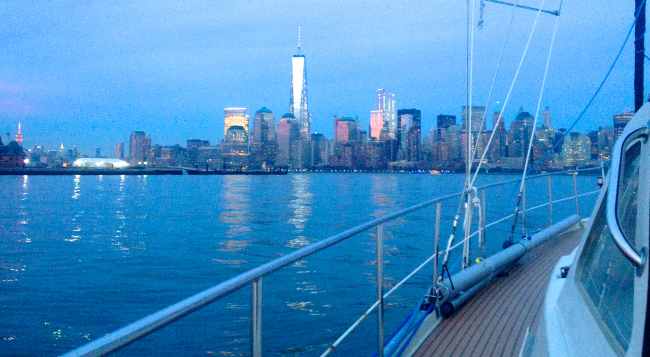 At the left edge, The Empire State Building, illuminated in red. Right of it, with a white spire, the Chrysler Building. In the center, the World Trade Center buildings (WTC One opens Nov 3, 2014), and to their right, Wall Street and Downtown.