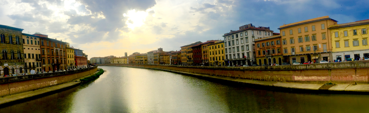 Looking downstream from the Ponte di Mezzo , located here since 1035 and rebuilt a few times since. The original Roman bridge that preceded it crossed the river on the street next to the eight building on the right. 6:52PM, 23 July, iPhone 6 Plus.