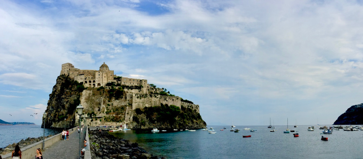 The Aragonese Castle at Ischia, with Peregrinus visible at anchor in the artificial bay created by the causeway built by King Alfonso V of Aragon, Naples, Sicily and diverse others, and uncle of King Ferdinand the Catholic, he who sent Columbus looking for the Indies. 9 September 2016, iPhone 6 Plus.
