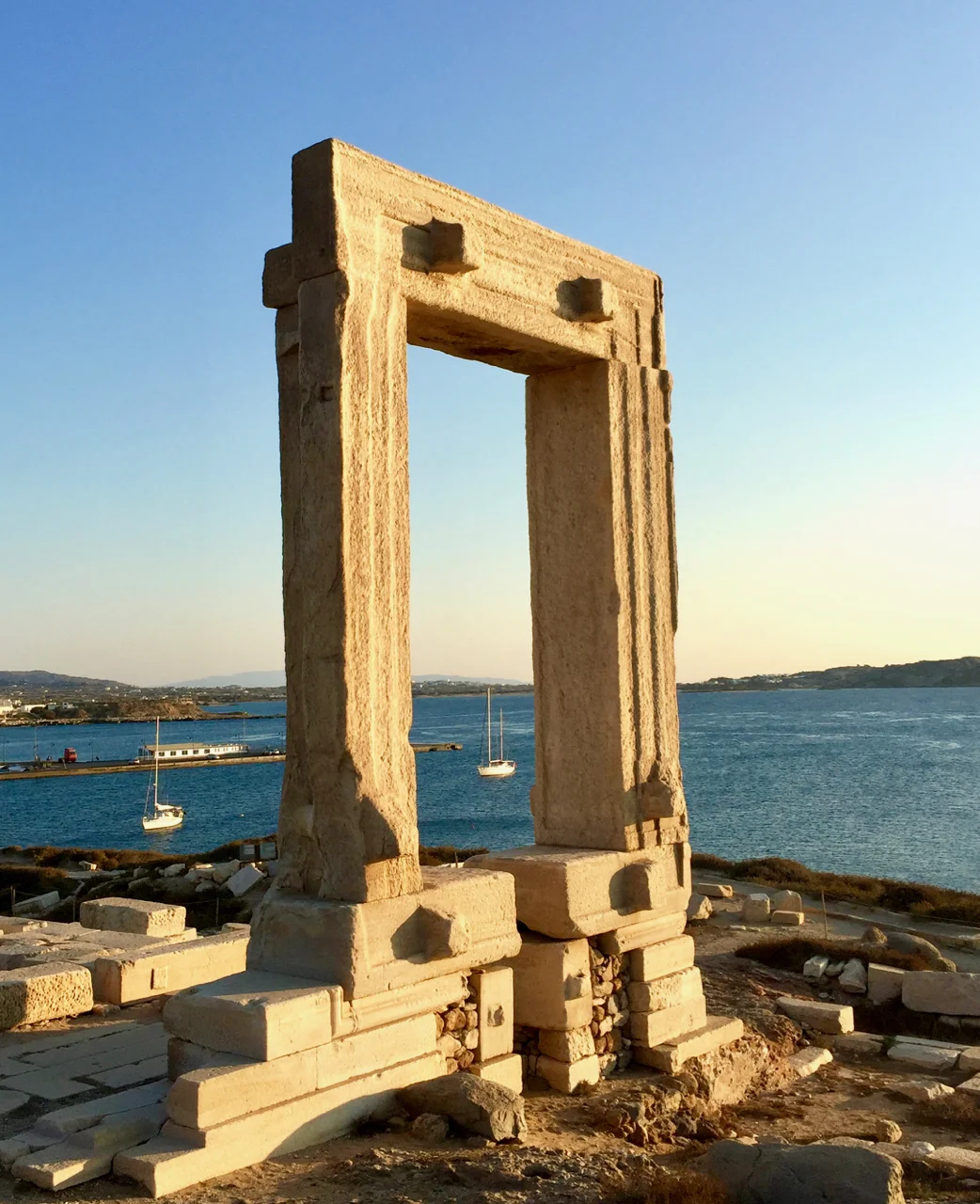 Peregrinus , a white-sailed ship, framed by the 20 foot-tall main door to the 530 B.C. Temple of Apollo. Naxos, 27 September 2017, iPhone 6 Plus.