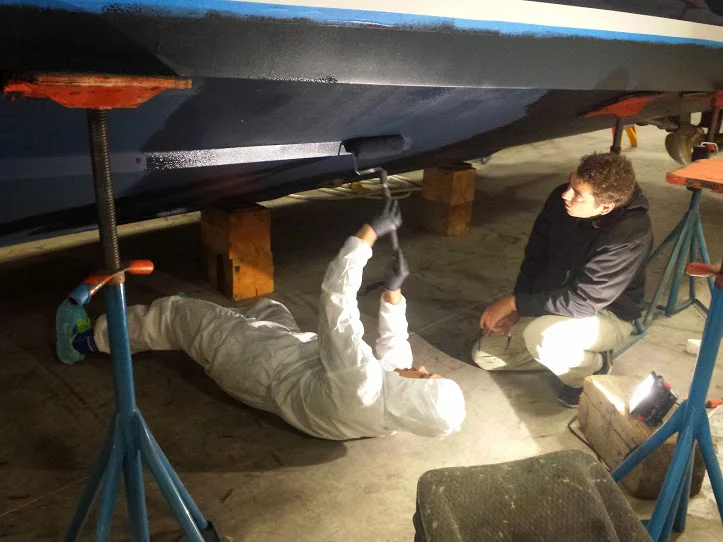 Matt painting the bottom of a new 39' Tiara Coronet with Trevor checking over the work.