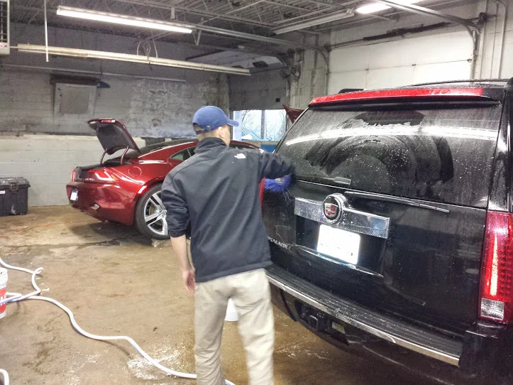 The crew hiding from the rain cleaning a lot of cars inside our new shop!