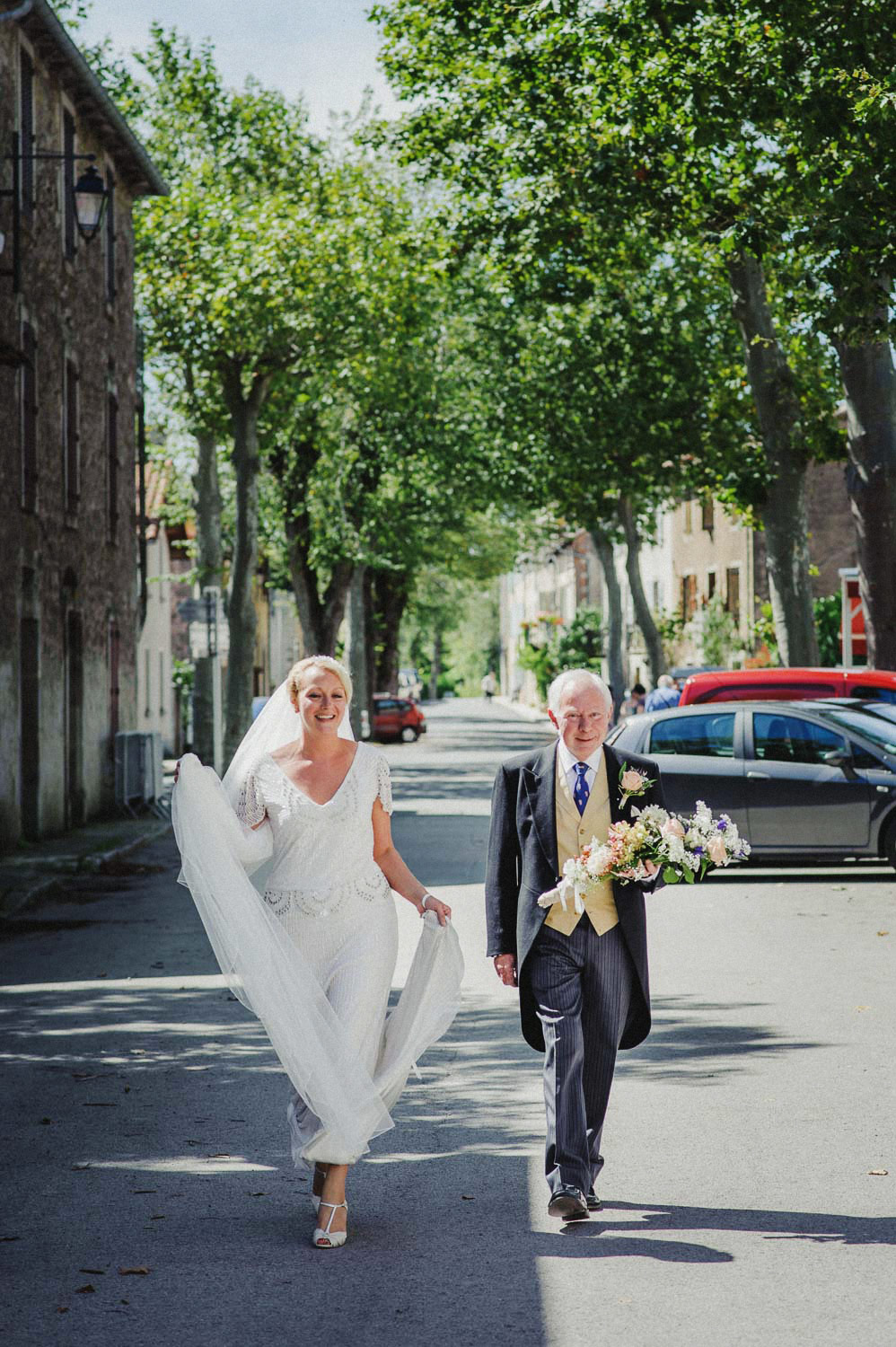 bride and father walking through french village