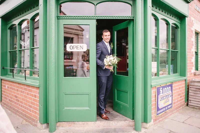 Groom emerging from vintage sweet shop at the Ulster Folk Museum wedding
