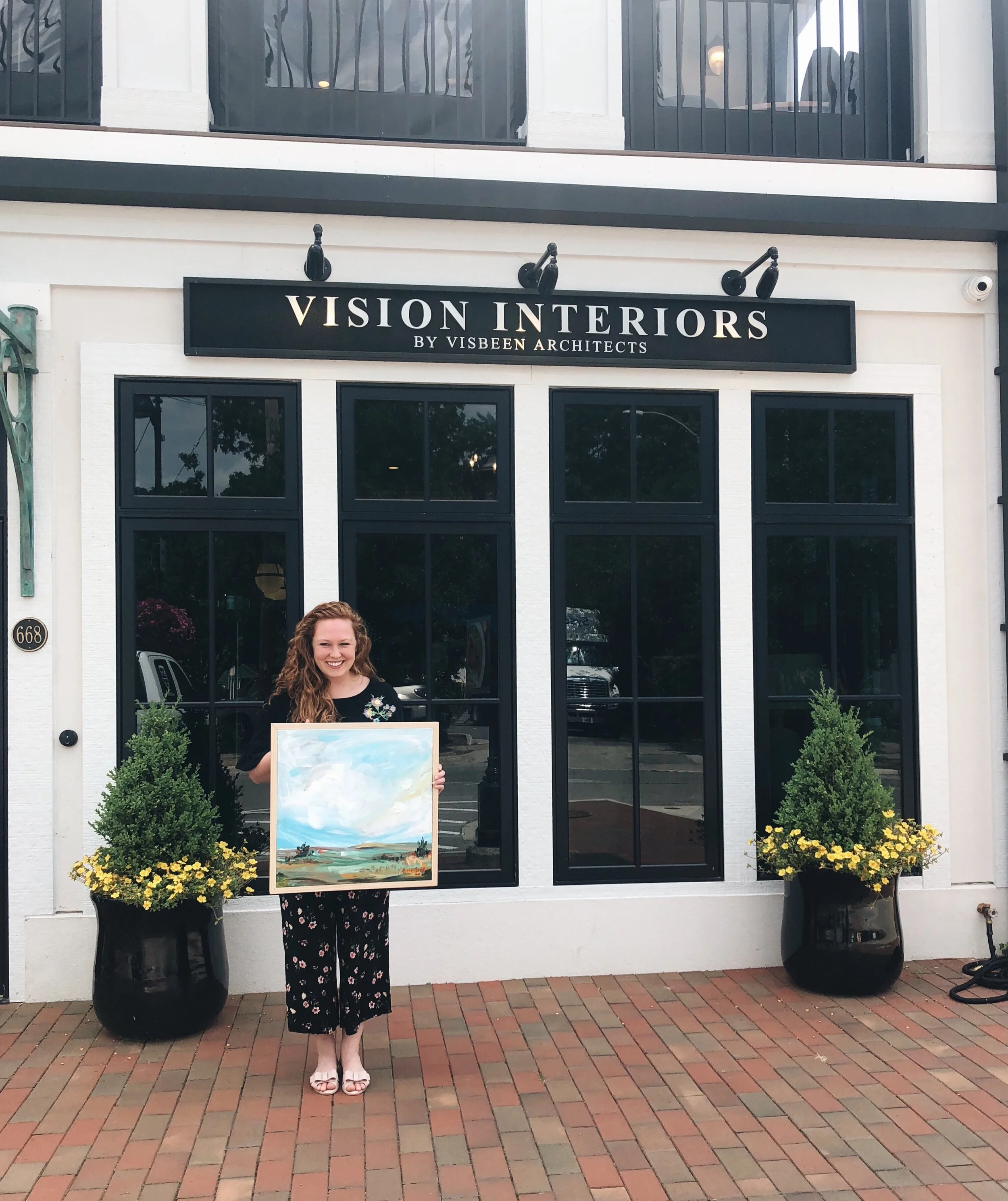 Artist holding "Take the Moment" framed in pine