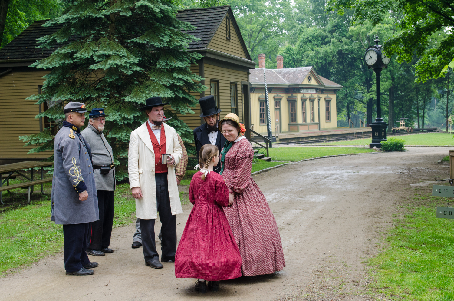 President Abraham Lincoln and President Jefferson Davis and their guards in casual conversation while a lady and her daughter pass by.