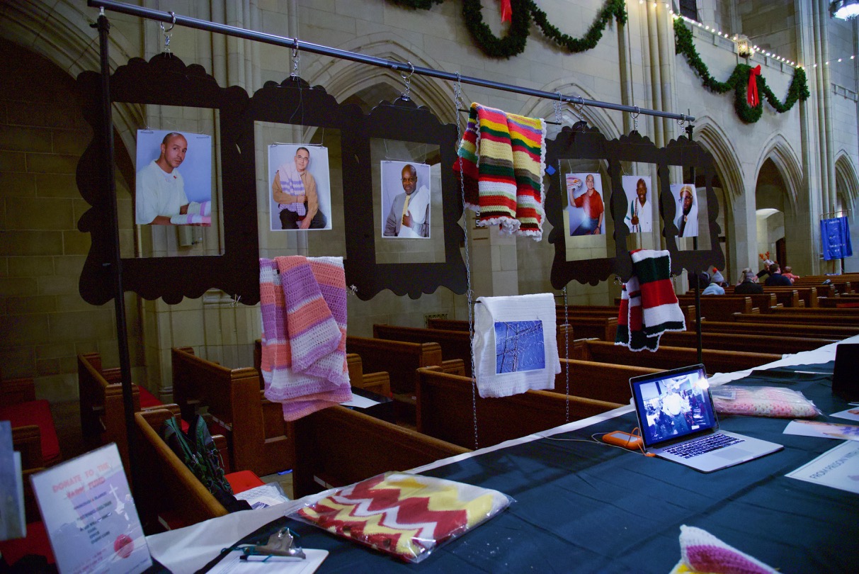   A DISPLAY OF MEN WHO CROCHET IN PRISON AND A SAMPLE OF THE BABY BLANKETS THEY MADE  