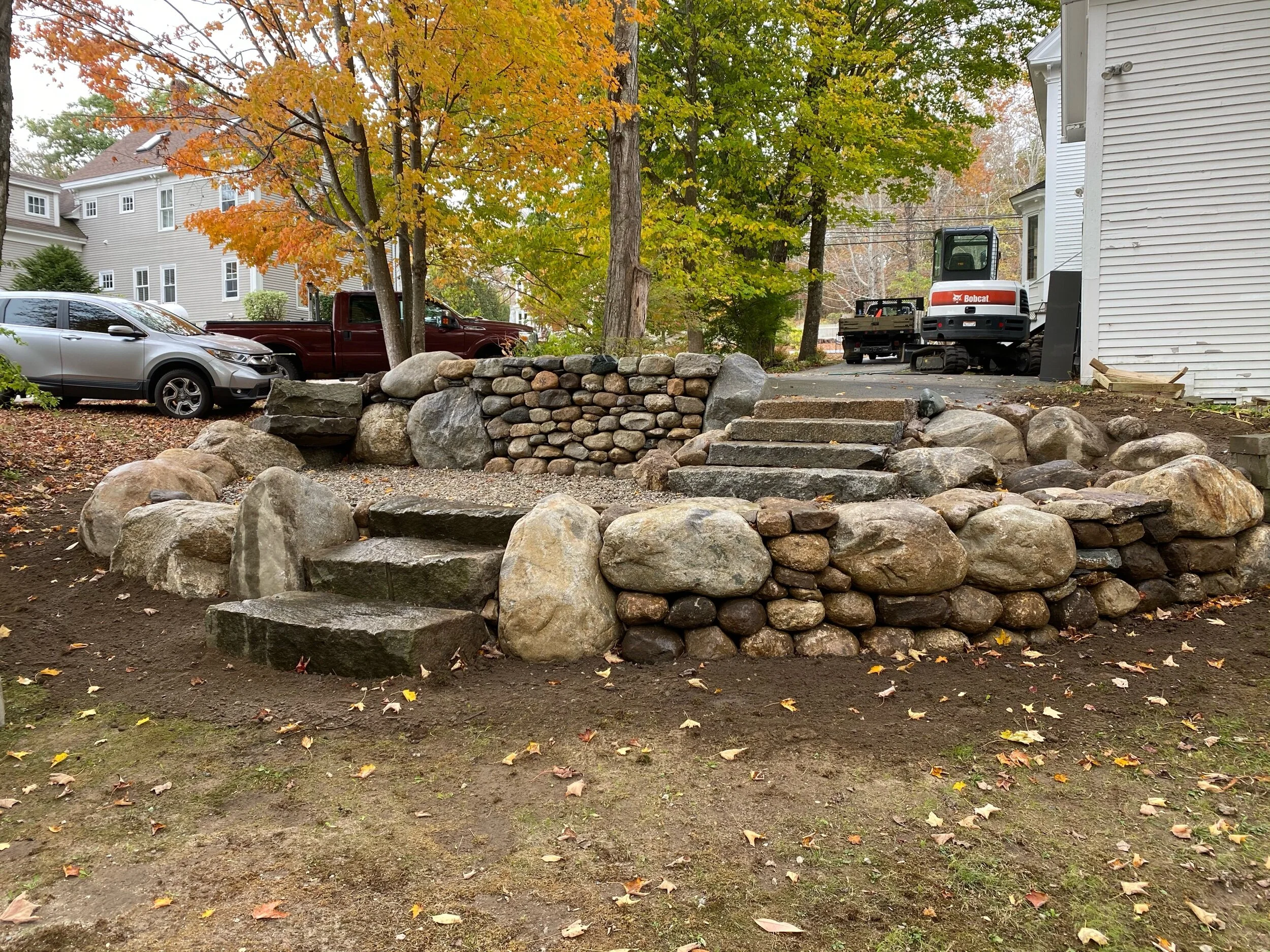 This is phase one of a project in Freeport using local boulders and glacial till stone to create this dry stone terrace.