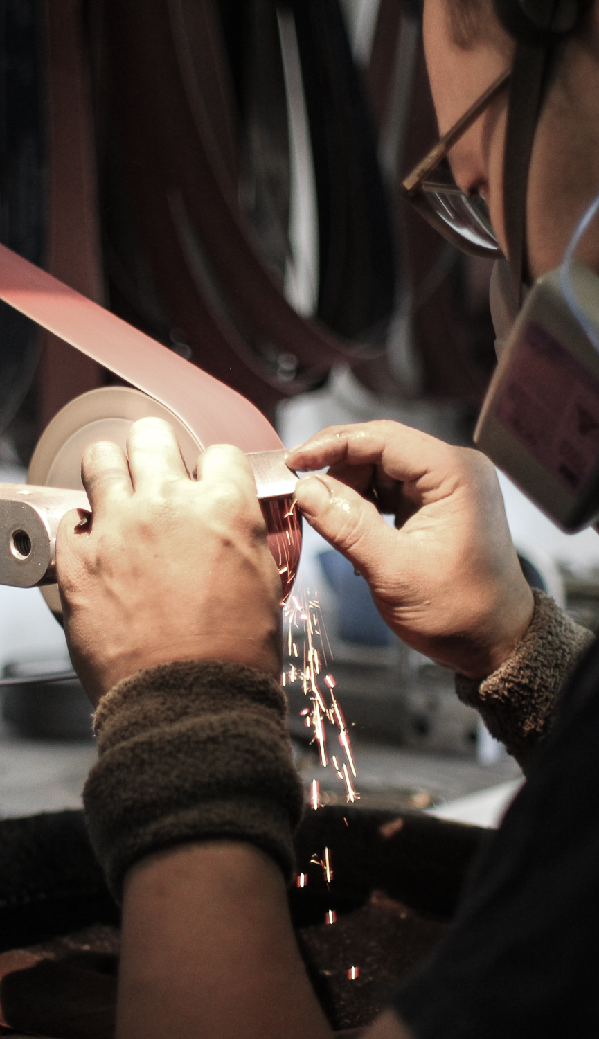 A razor smith putting a hollow grind on a straight razor.