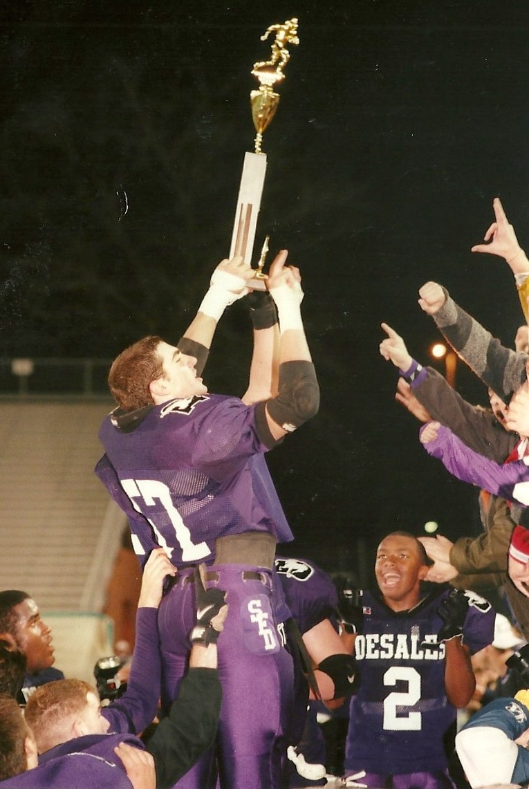 Joe Dura (57) shows off the trophy to the Stallion fans