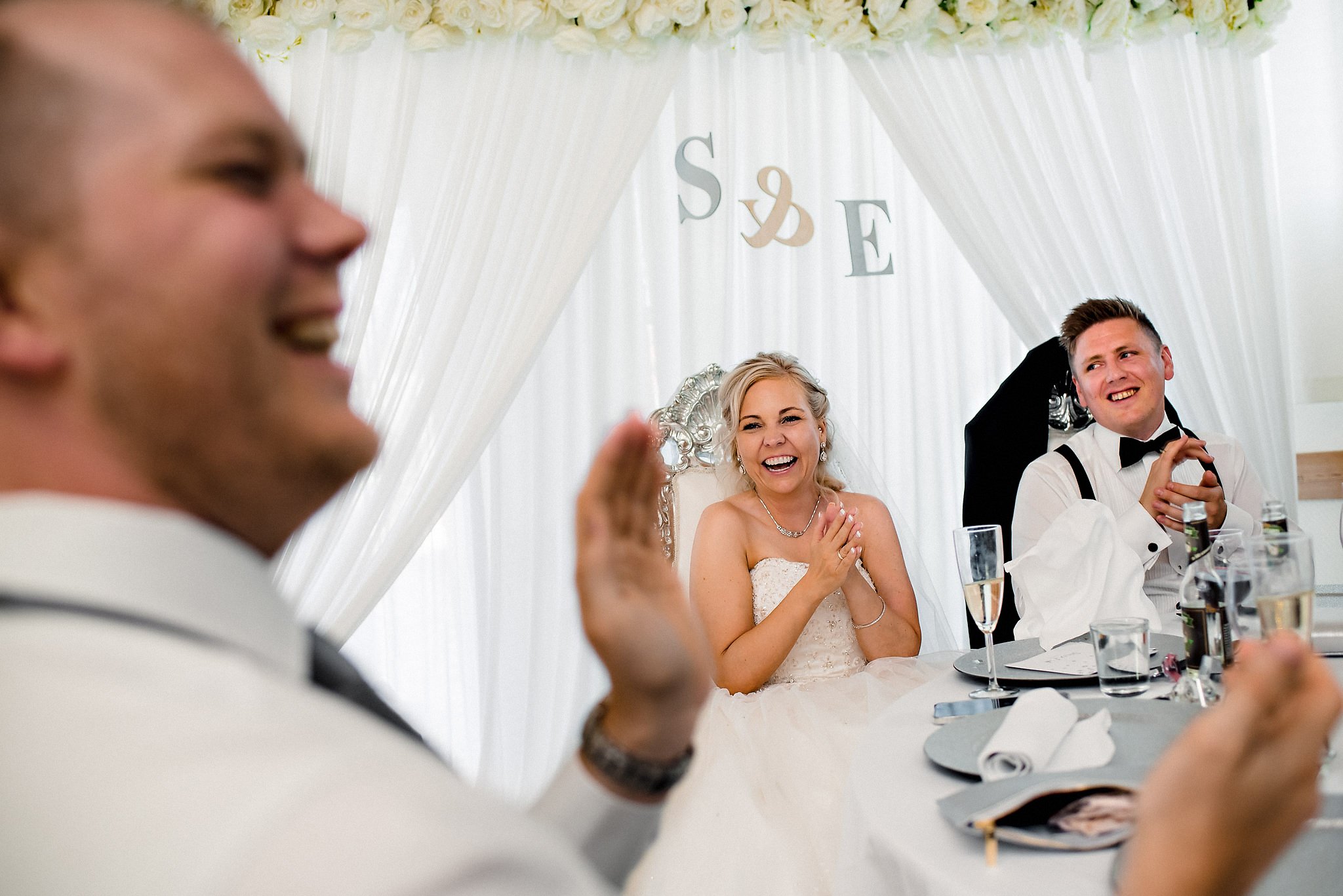 Bride and groom having fun during speeches during their wedding reception in Stavanger, Norway