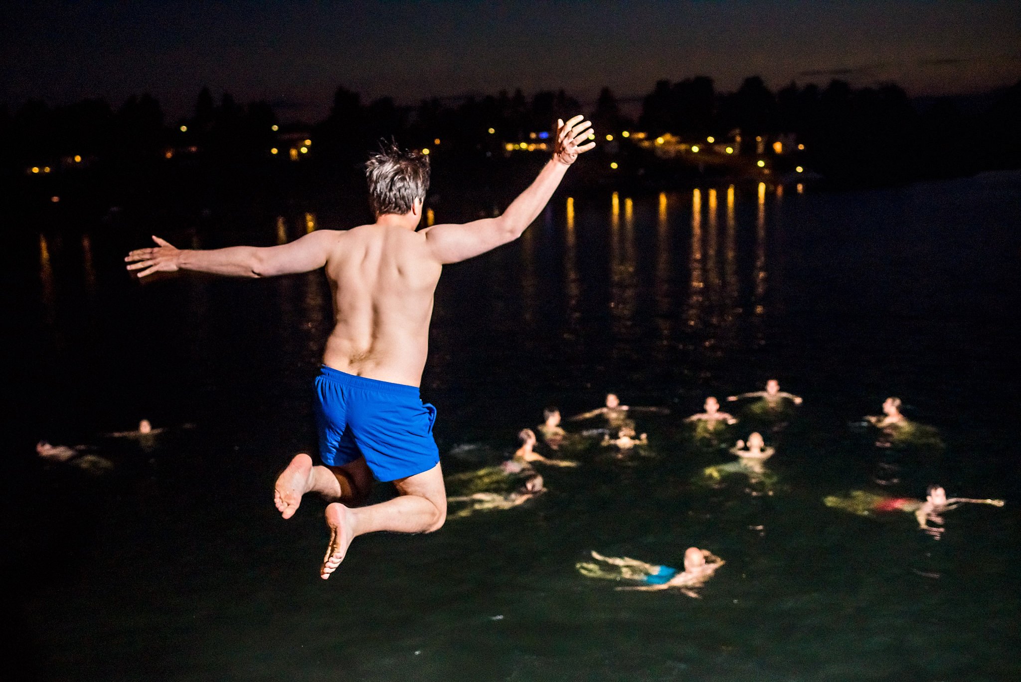 Wedding guests jumping in the ocean for a midnight swim after the wedding reception at Brønnøya outside Oslo