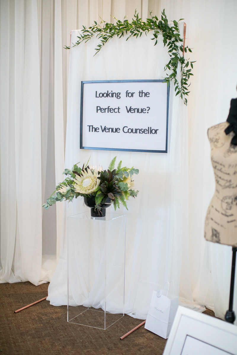 venue counsellor wedding show booth with florals and letter board