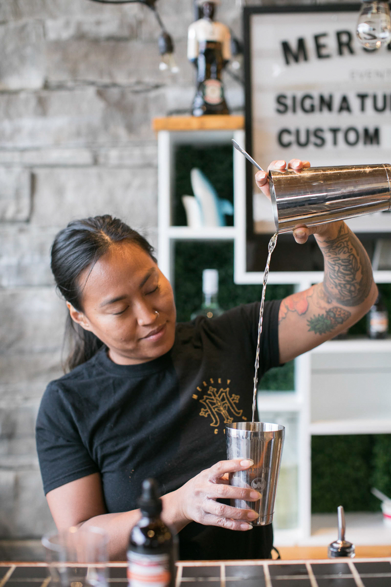 employee mixing and pouring custom cocktails