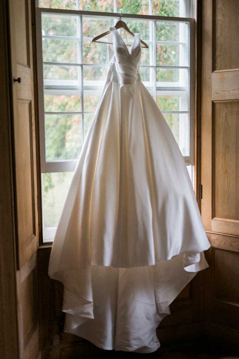  Classic wedding gown hanging in a window. 