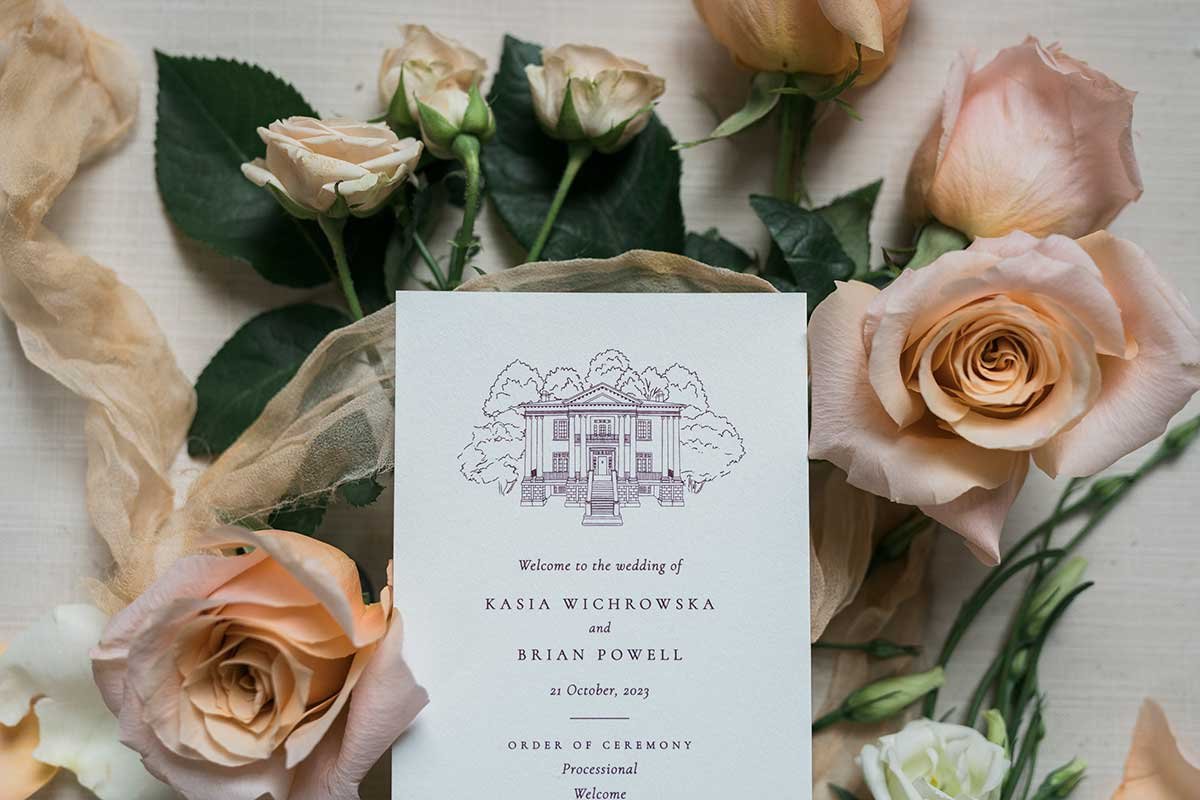  Close-up of wedding invitation arranged in a floral flatlay. 