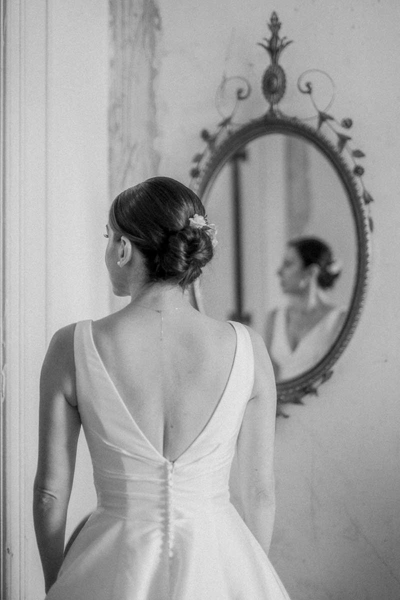  Bride getting ready, looking at her reflection in the mirror. 