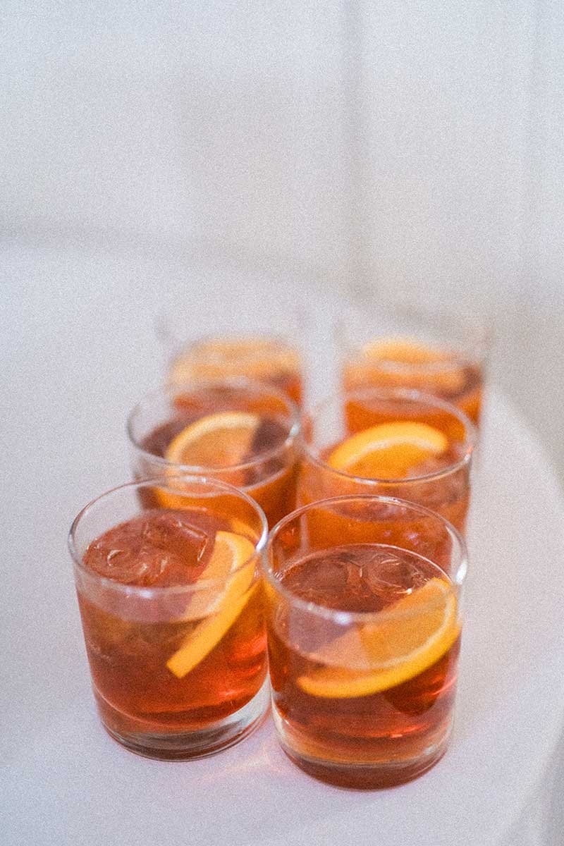  Signature cocktail garnished with orange slice. 