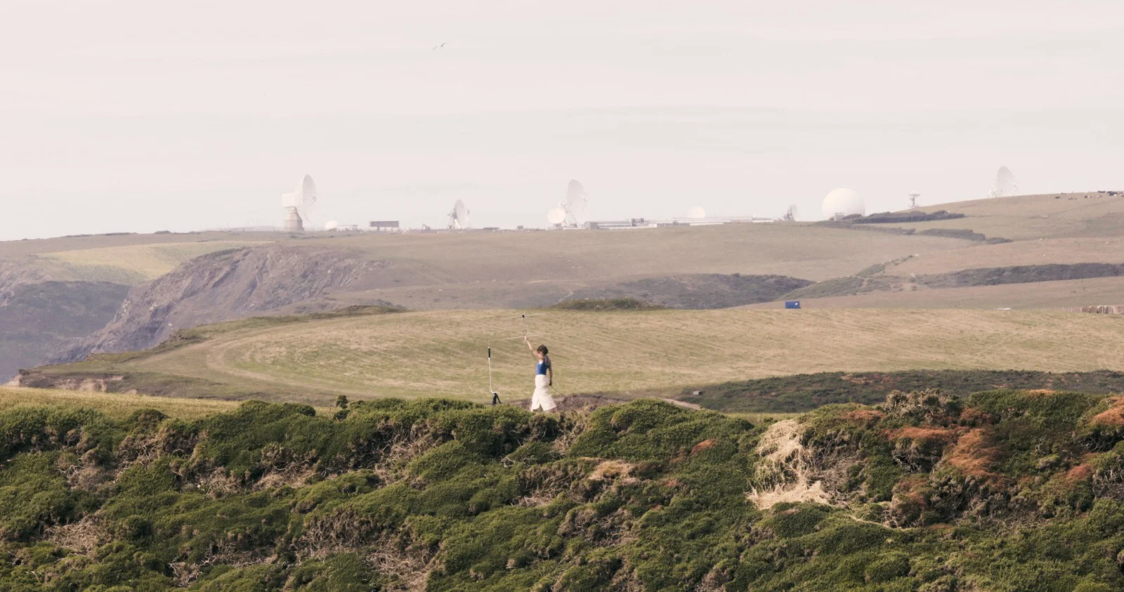 Satellite Séance : a performance involving gesture, live electromagnetic experimentation and decoding images of weather systems via transmissions from polar-orbiting NOAA satellites. Materials include a Turnstile Antenna, Funcube Dongle Pro +, SDR# and WXtoImg software. Performed on 12th July 2019 in the shadow of the GCHQ operated “Listening Station” in Bude, Cornwall, where civilian data is captured and stored through internet probes, and the NSA-GCHQ collaborative interception of satellite downlinks over the Atlantic; Photography by Matthew Philips