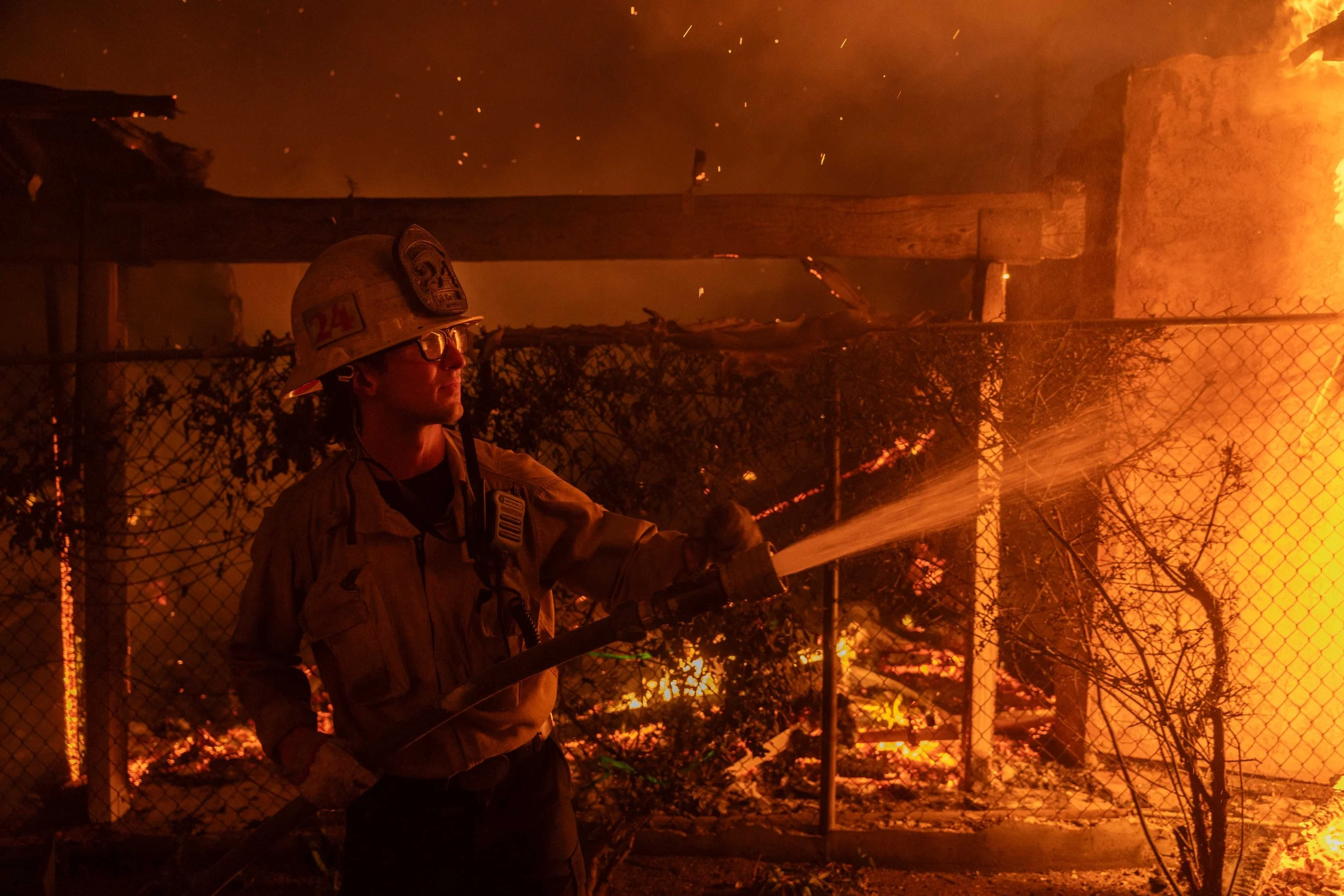 Firefighters work on a home during the Eaton Fire in Altadena on January 8, 2025.