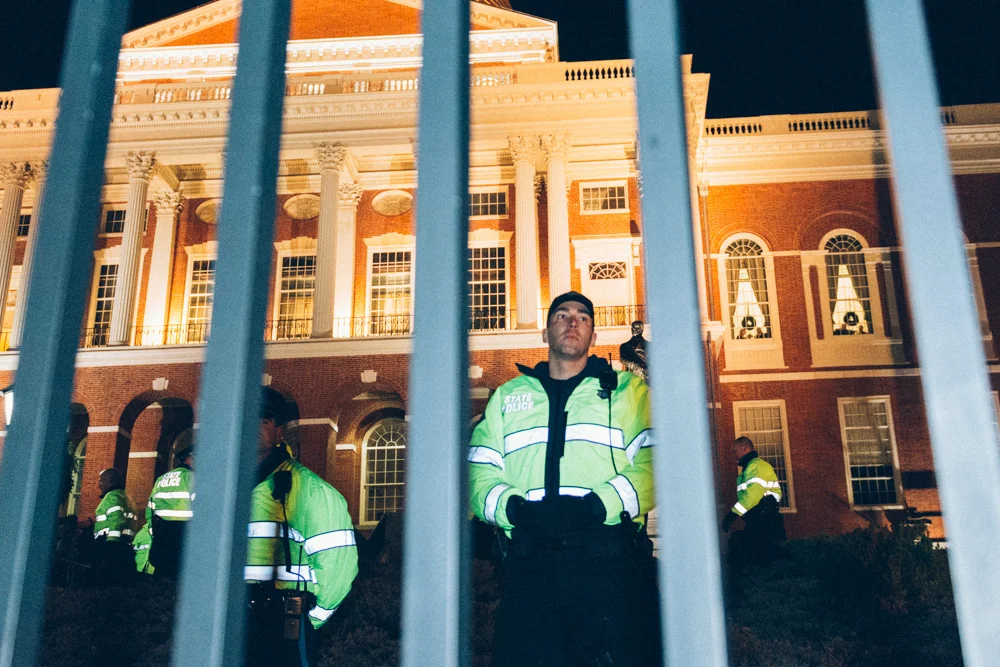 Just beyond the fence blocking the front of the state house was a phalanx of additional state troopers, standing a few feet apart.