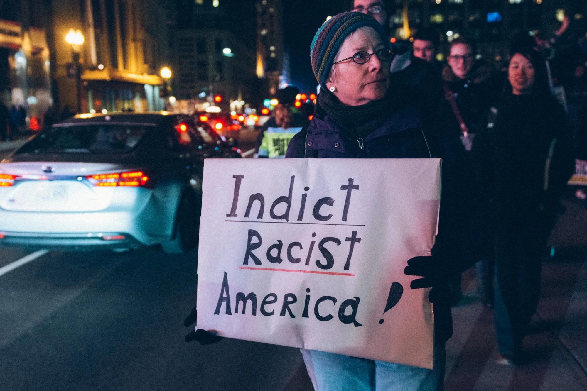 A woman standing with a sign on Tremont Street, just outside the Commons.