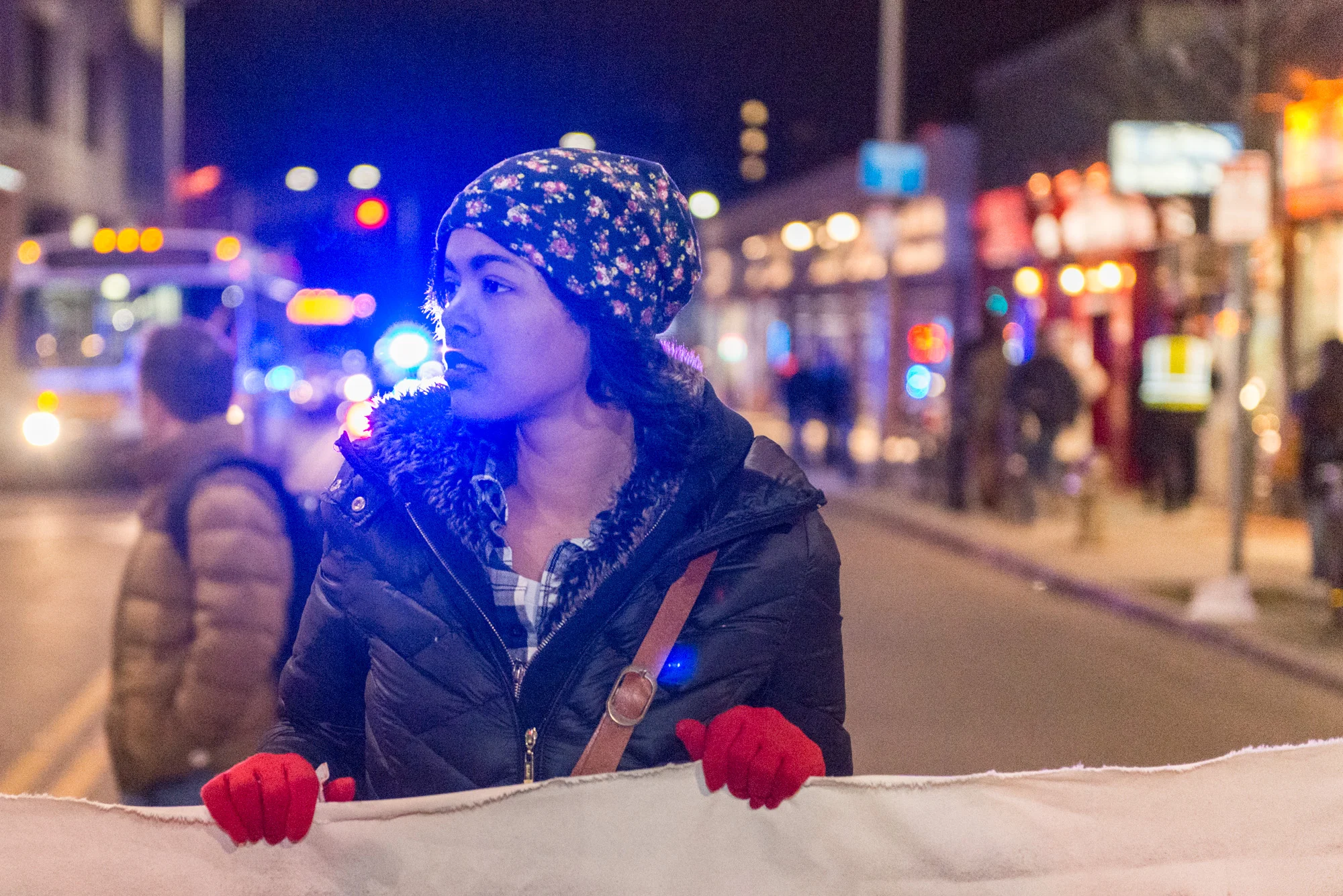 Student holding banner on Mass. Ave. in Central Sq.