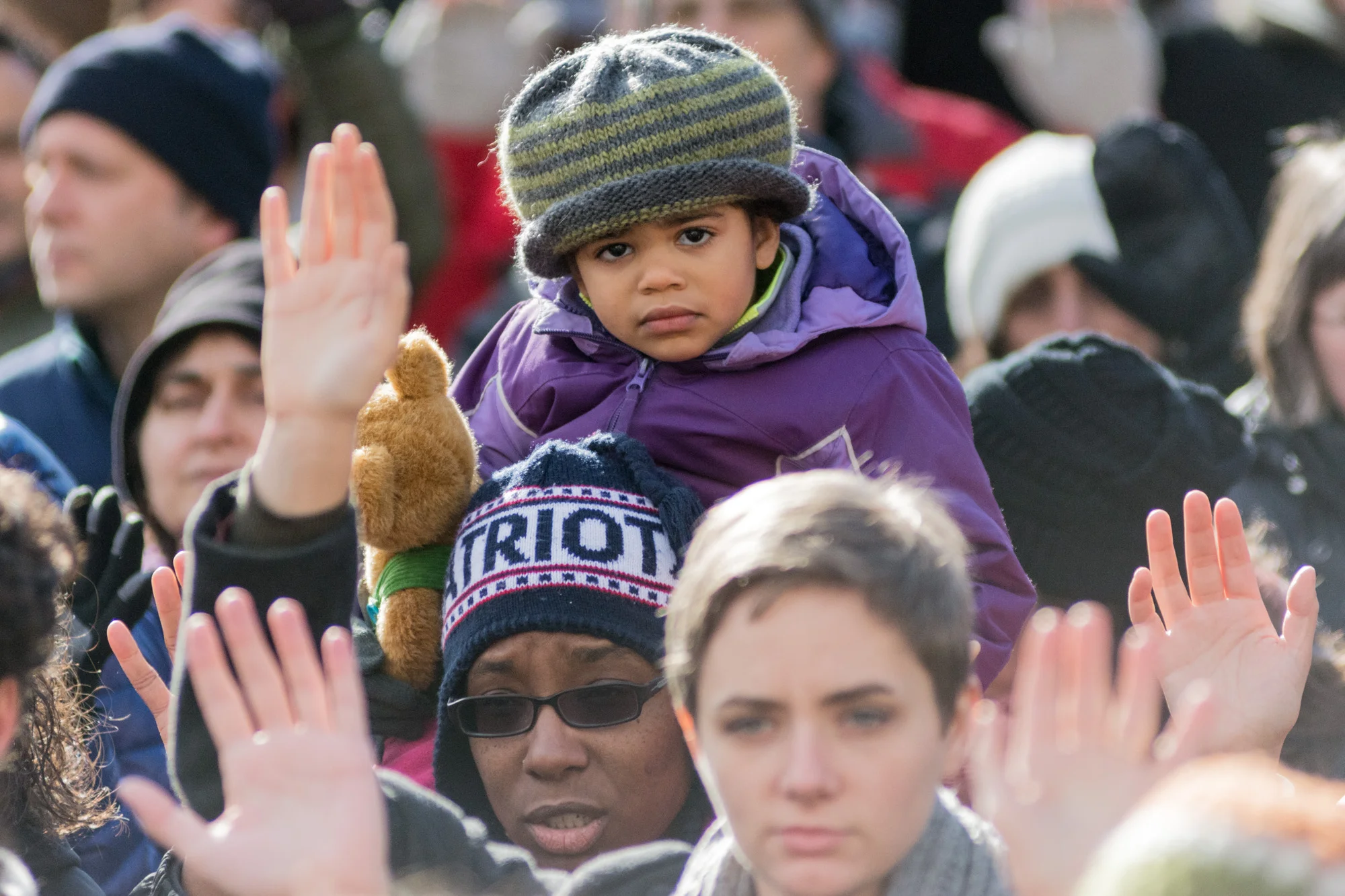 One of many children attending the protest on the shoulders of her father