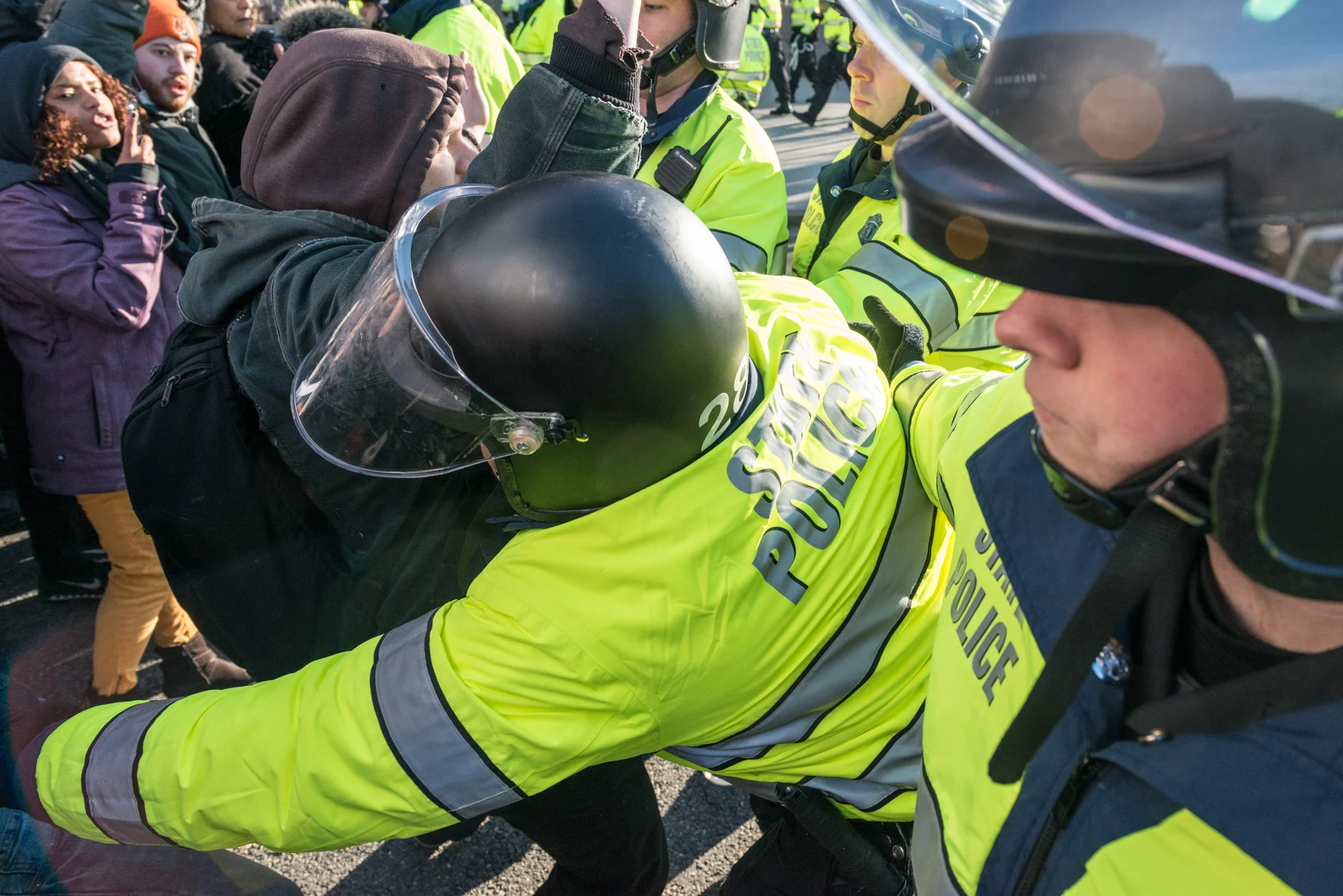 One protester being pushed back by a State Trooper