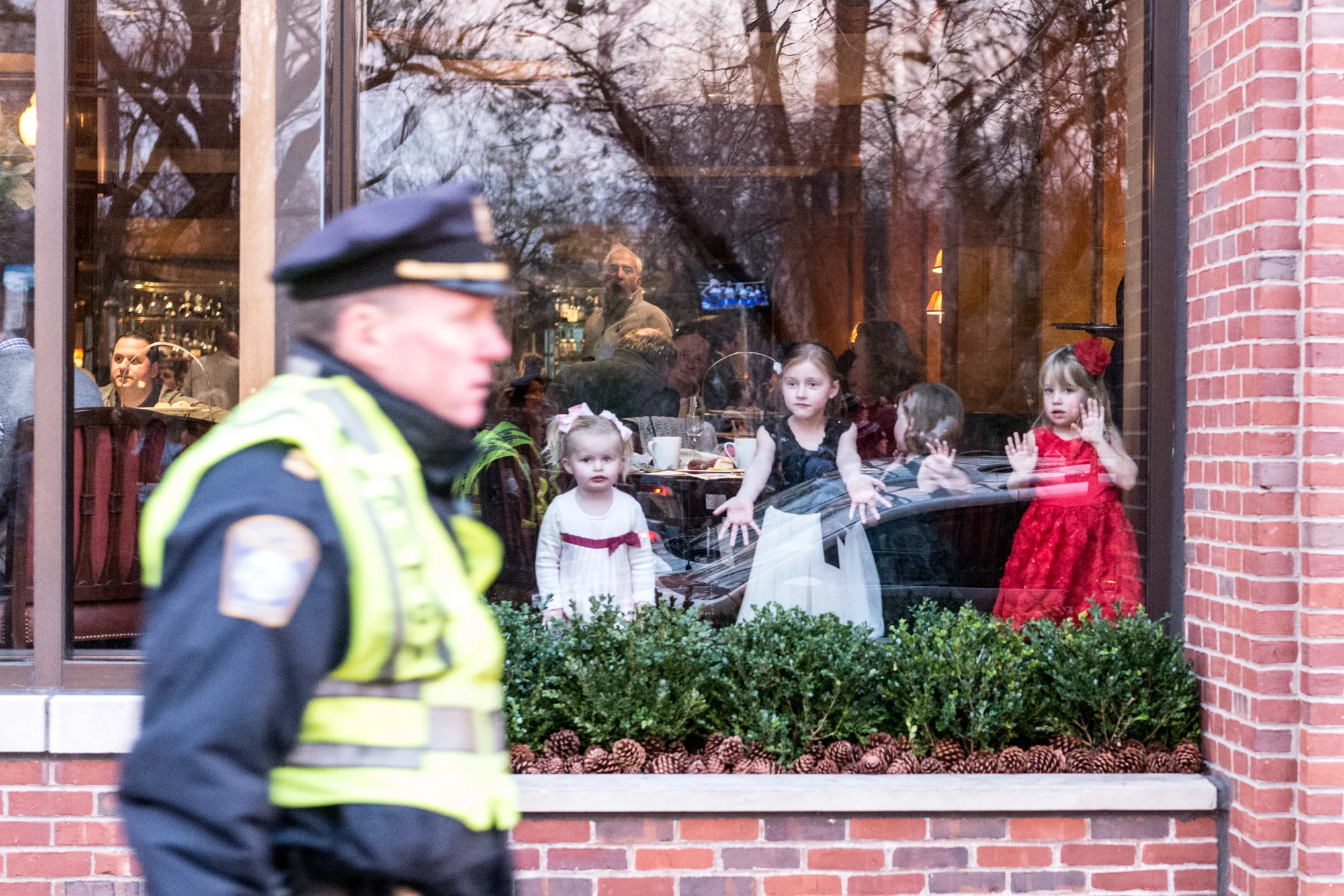 Three little girls looking at the marchers from a restaurant window on Boylston Street