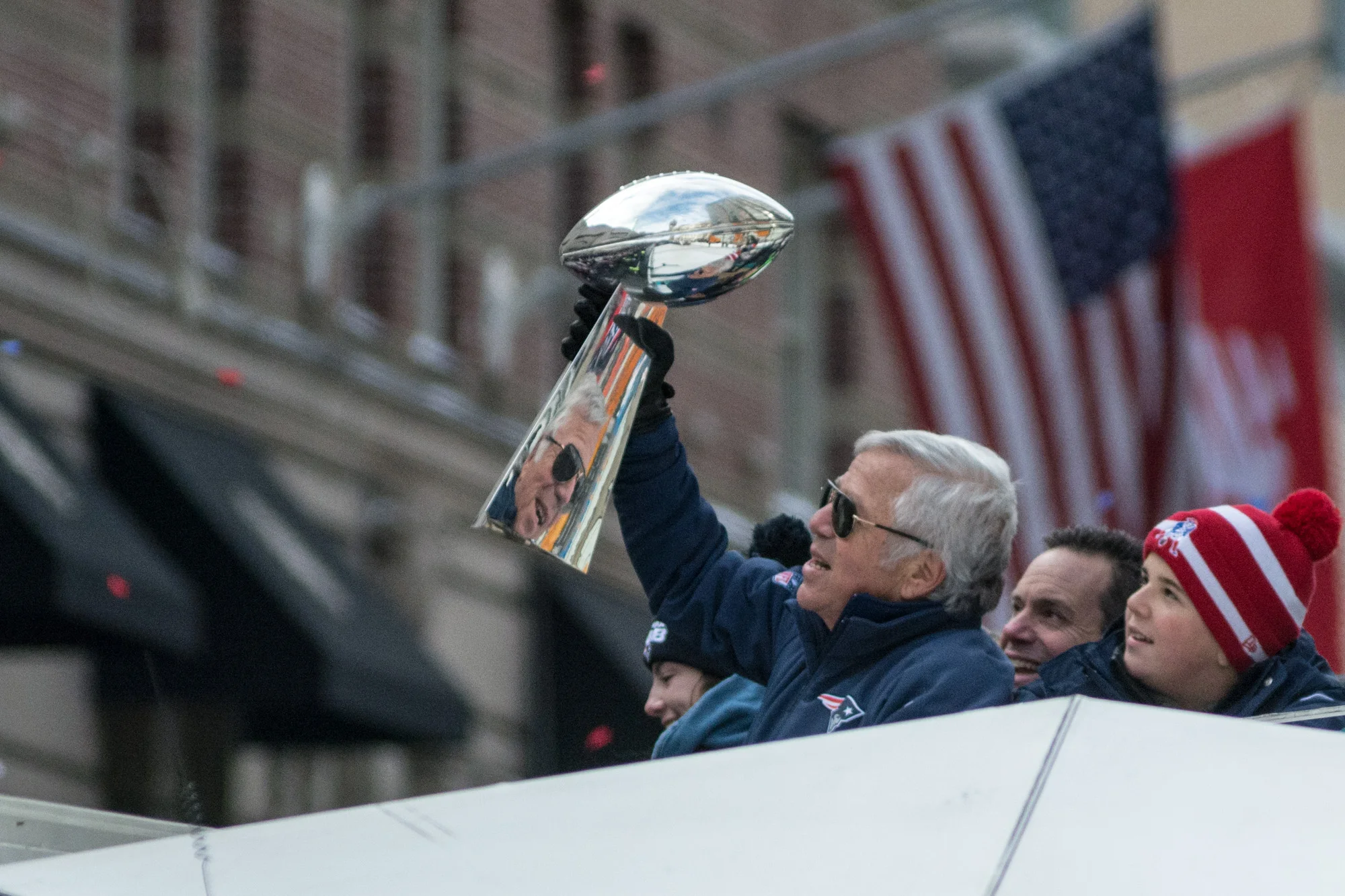 Patriots owner Bob Kraft holding one of four Vince Lombardi Trophies