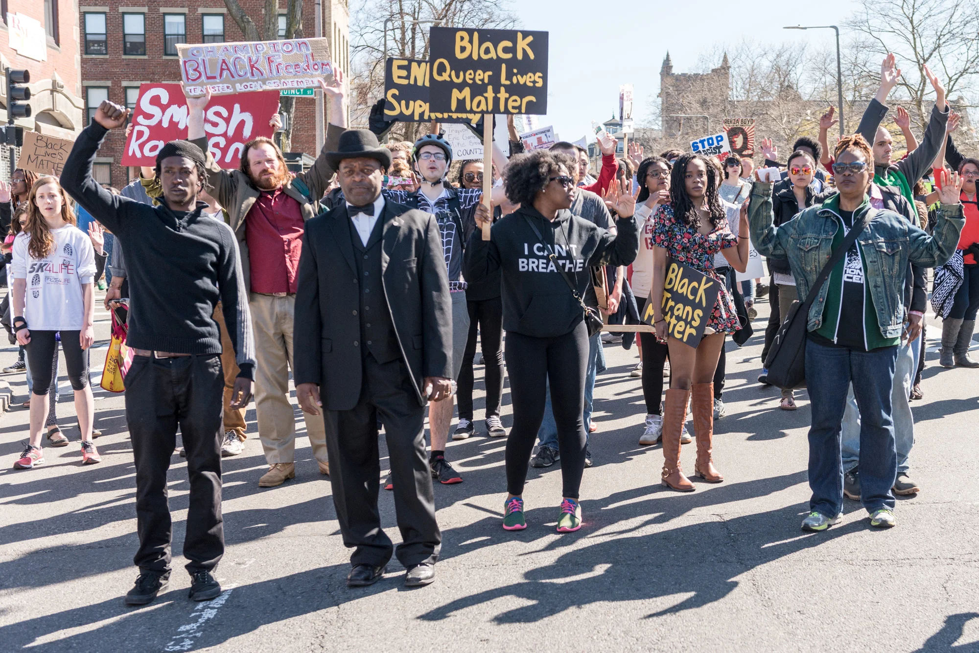 Marchers stopped in the street with hands up