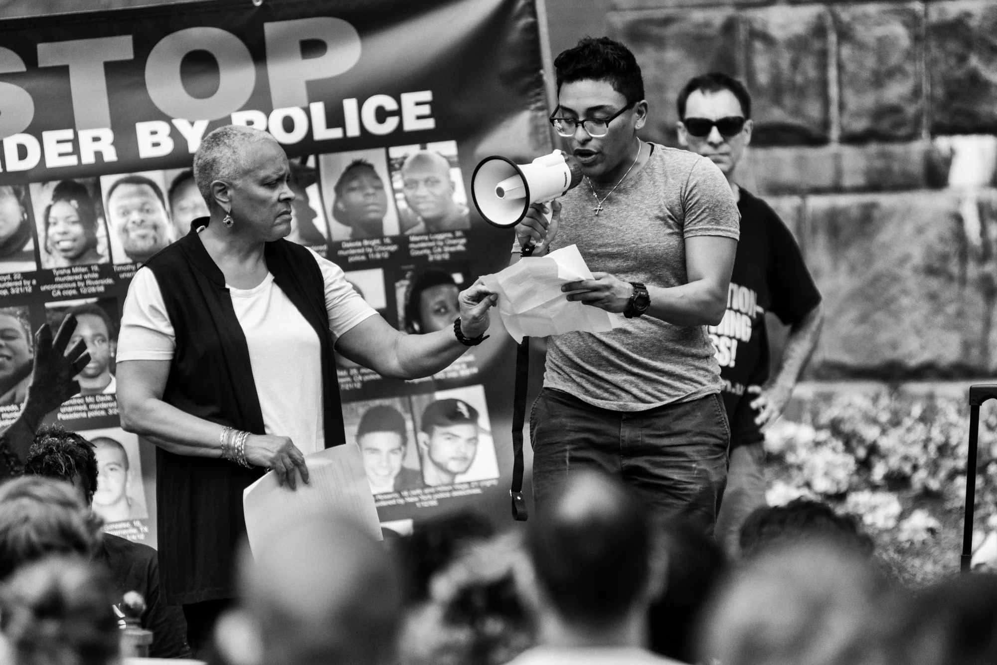 A speaker reading names of trans people of color who have been killed this year